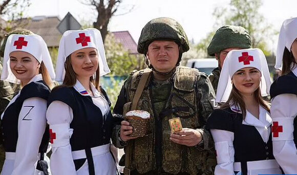 Οι «μαζορέτες» της ρωσικής εισβολής: Φοράνε στολή νοσοκόμας με έμβλημα «Ζ» και ποζάρουν δίπλα σε στρατιώτες και τανκς